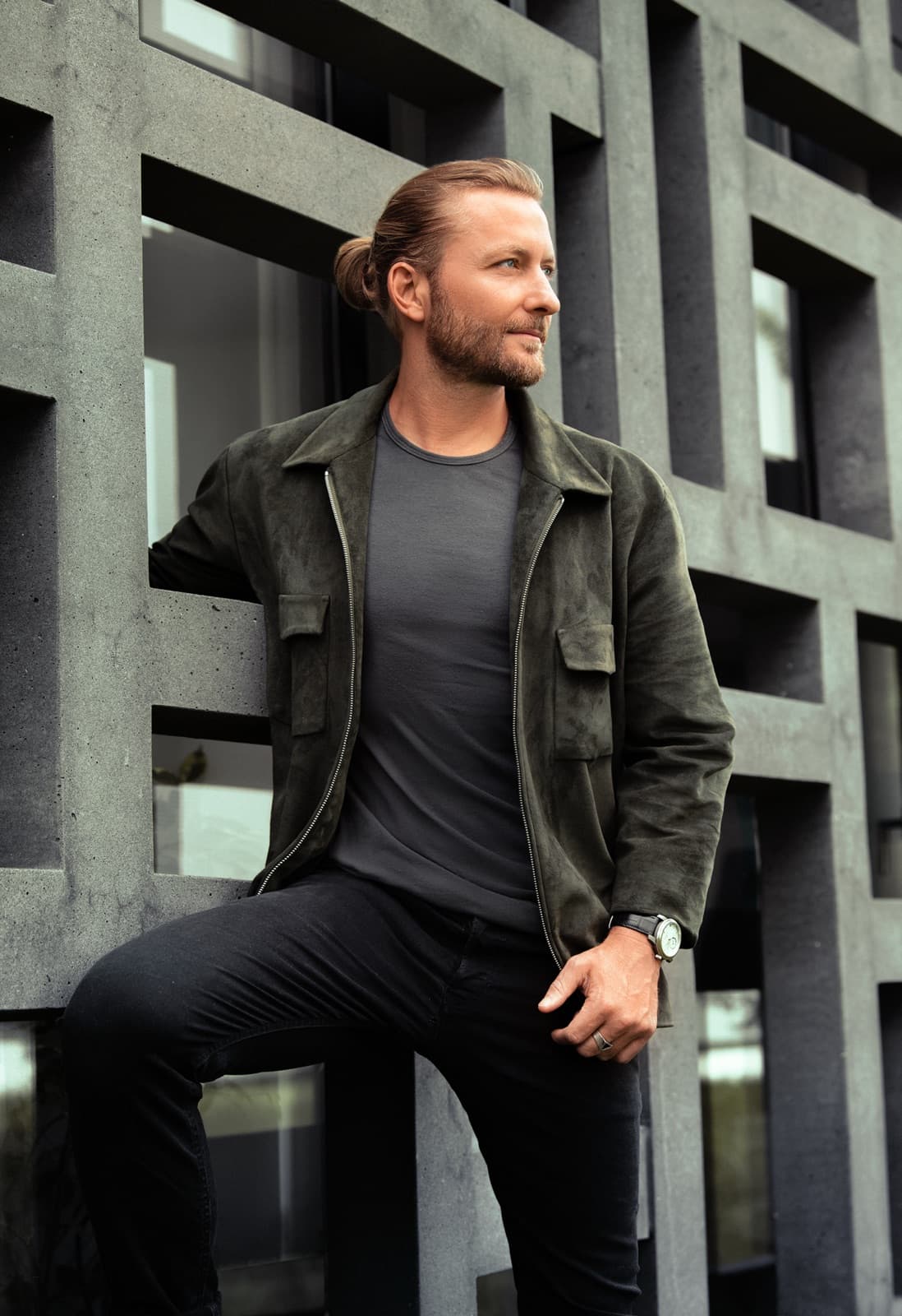 Victor Mathys in a khaki suede jacket against rectangular architecture